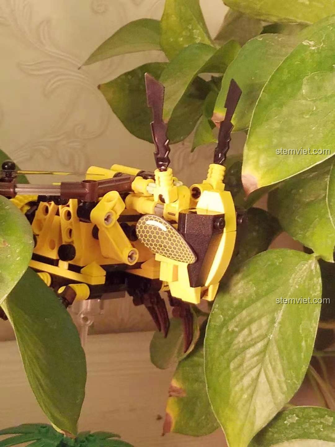 Mô hình Ong Vàng Cơ Khí Sembo 703200 trong khung cảnh rộng hơn giữa cây xanh, tạo điểm nhấn.