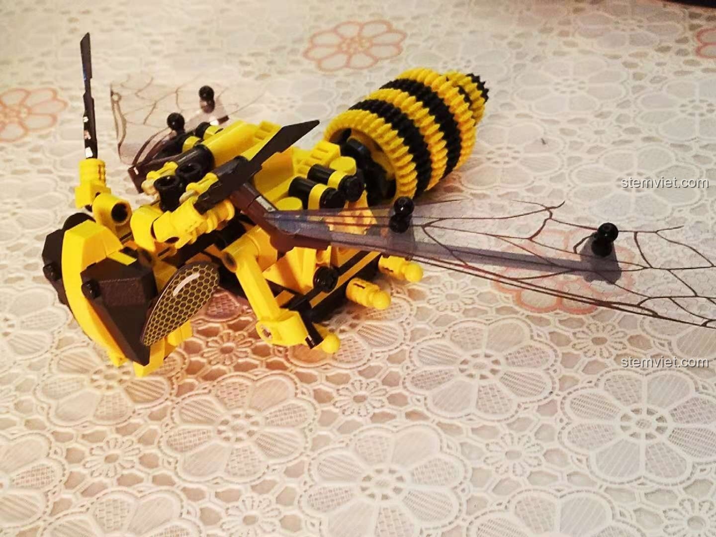 Cả hai mô hình Chuồn Đỏ Cơ Khí Sembo 703300 và Ong Vàng Cơ Khí Sembo 703200 được cầm trên tay bé, so sánh kích thước.