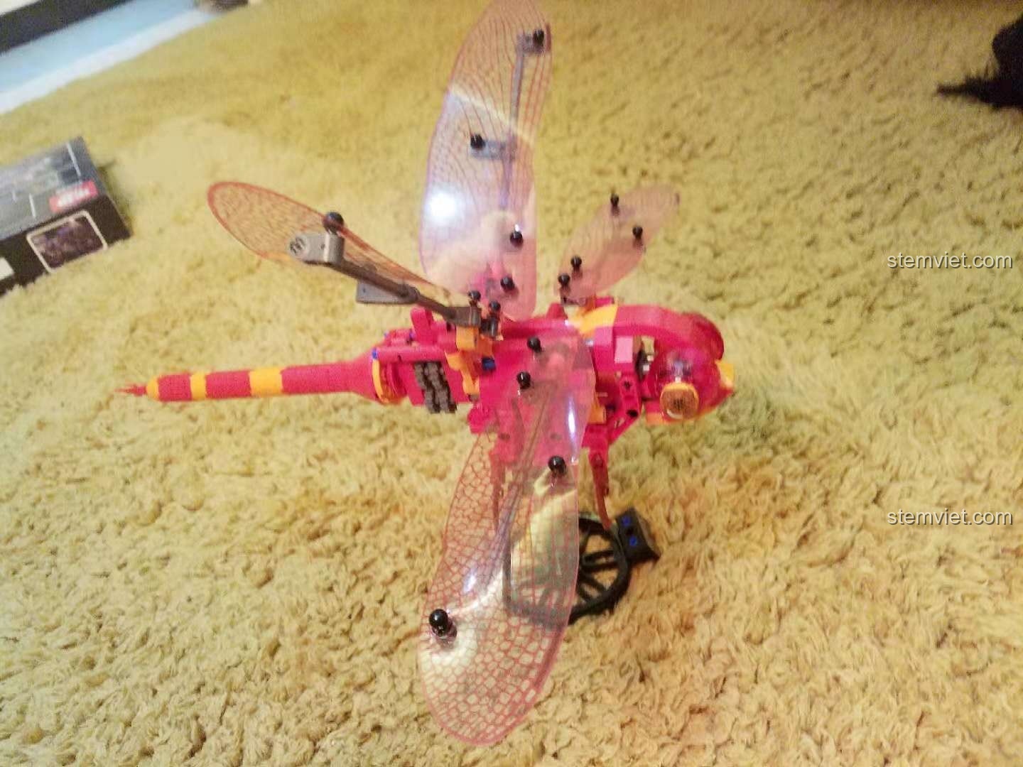 Mô hình Chuồn Đỏ Cơ Khí Sembo 703300 đã hoàn thành, đôi cánh trong suốt và màu sắc nổi bật, sẵn sàng trưng bày.