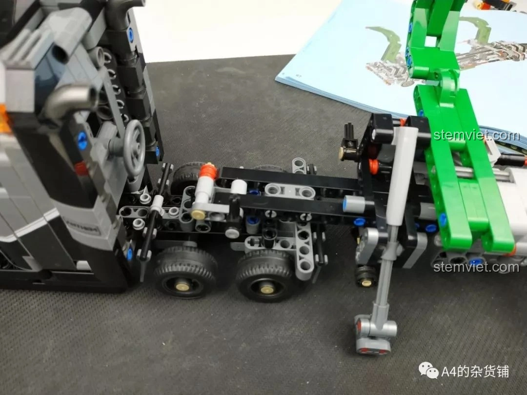 Cần cẩu đã được gắn vào khung xe tải, với các chi tiết màu xanh lá cây và xám, của bộ lắp ráp Xe Tải Container Cơ Khí SEMBO 703940.