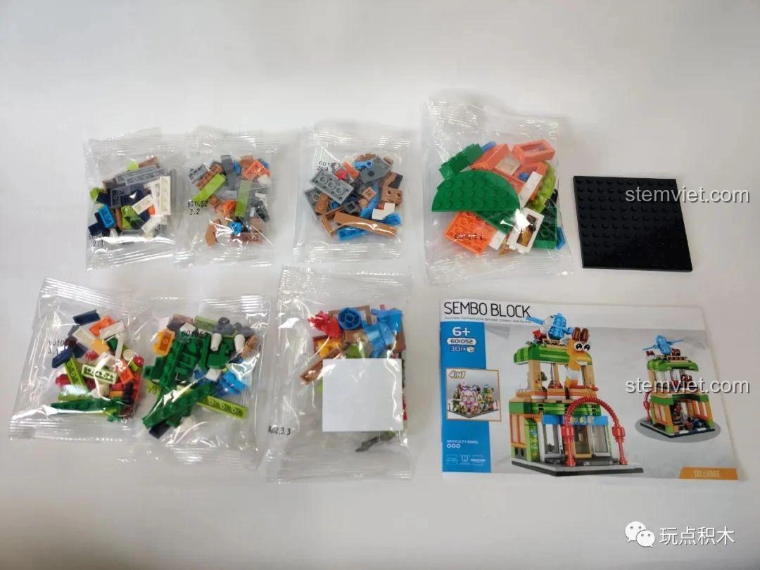 Toàn bộ linh kiện bên trong hộp Bộ Lắp Ghép Cửa Hàng Đồ Chơi Sembo Block 601052, bao gồm các túi mảnh ghép và sách hướng dẫn.