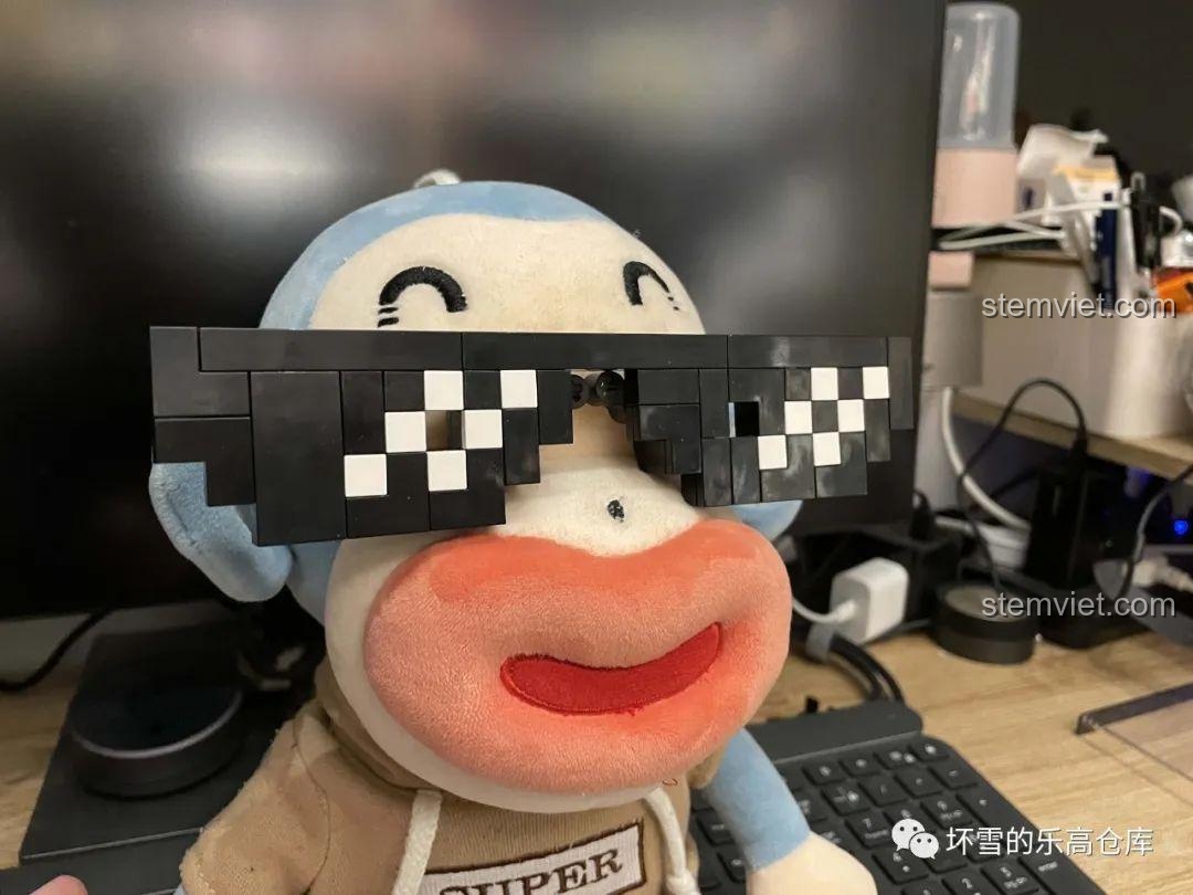 Một mô hình thú nhồi bông đang đeo chiếc kính pixel từ bộ Sembo 707901C, thể hiện tính linh hoạt của sản phẩm.