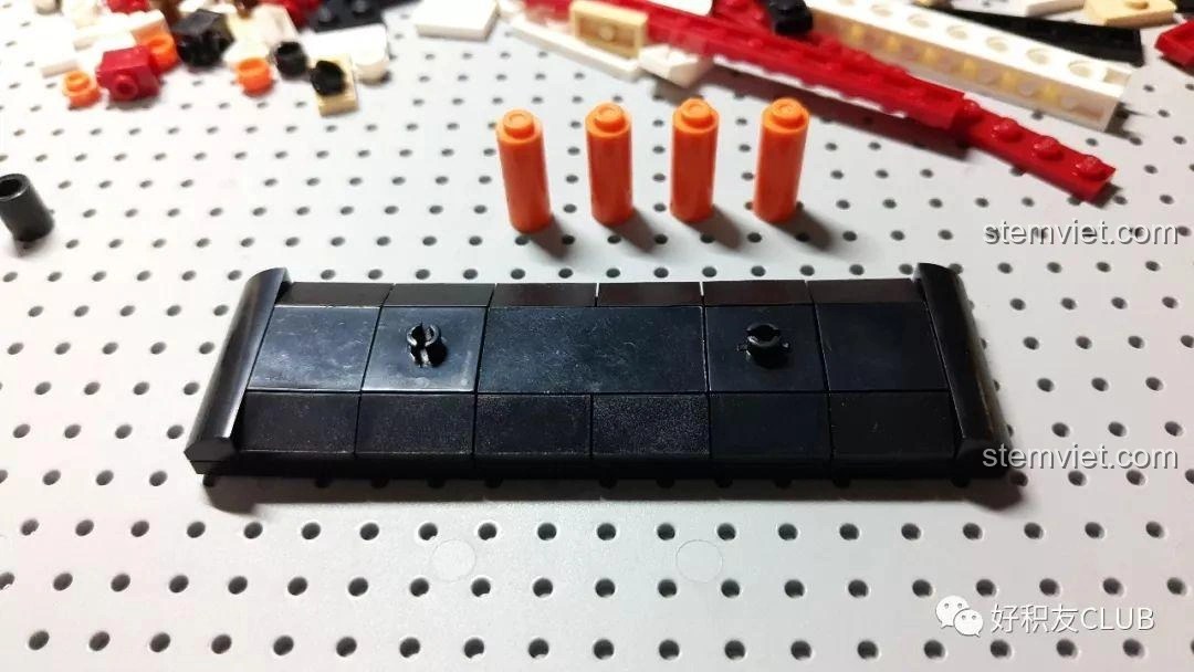 Quá trình bắt đầu lắp ráp phần đế của mô hình tàu Titanic Sluban M38-B0576, các mảnh ghép đen tạo thành nền vững chắc.