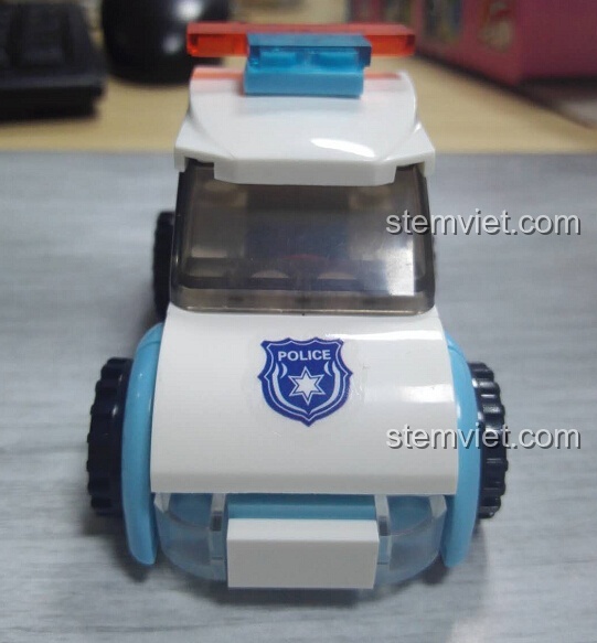 Mặt trước của xe cảnh sát Sluban M38-B0600B, nổi bật với logo cảnh sát và màu xanh trắng.