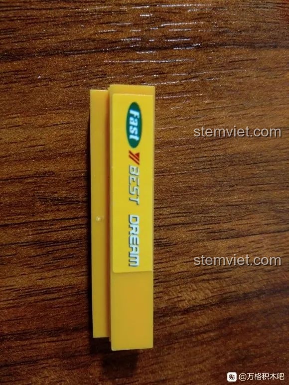 Ảnh cận cảnh một mảnh ghép màu vàng có in chữ 'Fast Best Dream' của bộ lắp ráp Sluban ORV越野车.