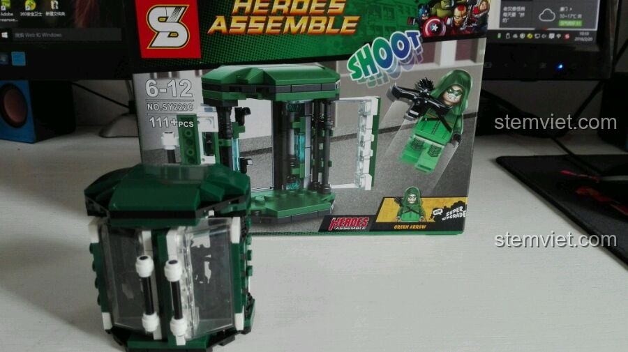 Khoang chứa Green Arrow SY222C đã lắp ráp, đặt trước hộp, với tông màu xanh lá cây và trắng chủ đạo.