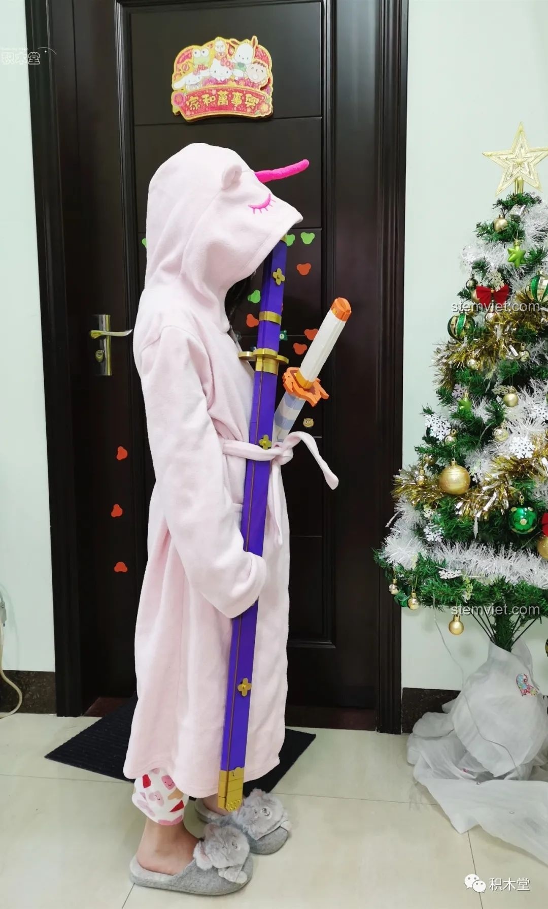 Bé trai cầm cả Thanh kiếm Enma của Zoro TEC Creators 1502 và kiếm Demon Slayer, thể hiện sự đa dạng.