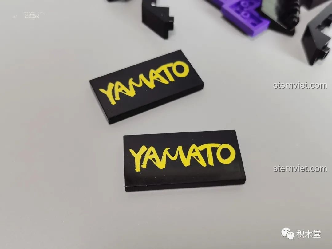 Các mảnh ghép in chữ 'YAMATO' màu vàng trên nền đen, chi tiết độc đáo của Thanh kiếm Enma.