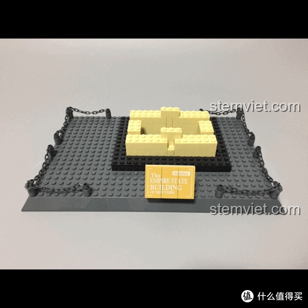 Phần đế của mô hình Empire State Building đang được lắp ráp, với các mảnh ghép màu xám và vàng.