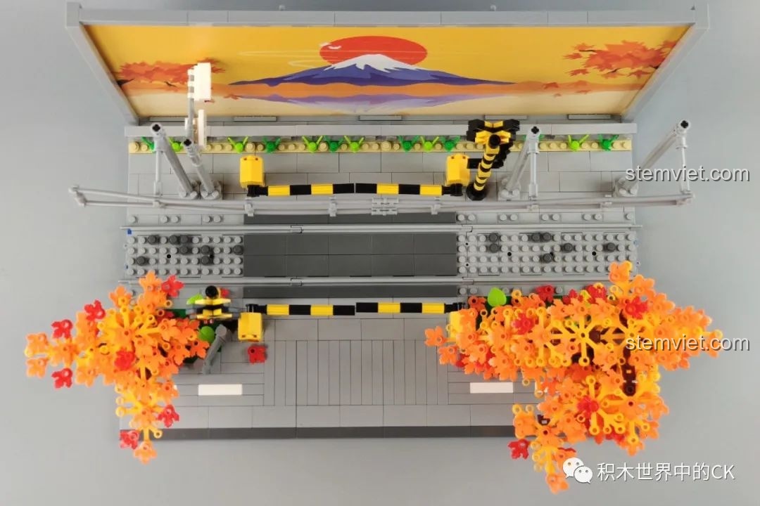 Đoàn tàu điện Kamakura chạy qua giao lộ với minifigure Sakuragi Hanamichi đứng nhìn trong mô hình Wekki 506000.