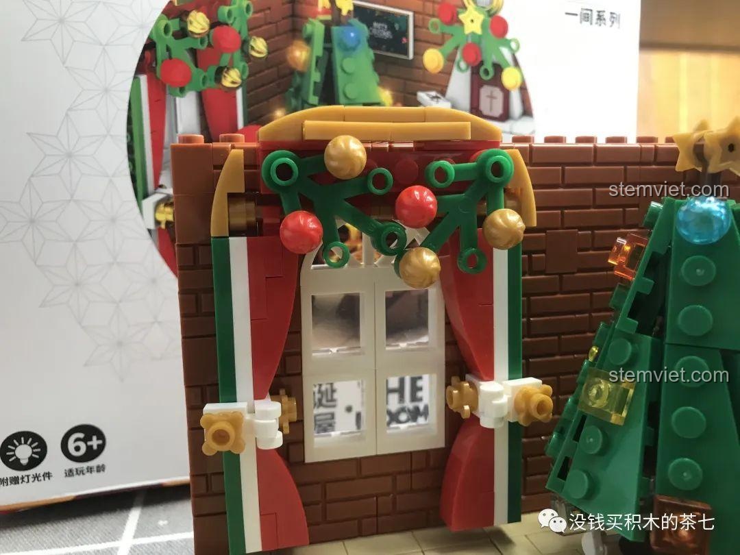 Cửa sổ của bộ lắp ráp Wekki 506001 Ngôi Nhà Giáng Sinh được trang trí vòng nguyệt quế.