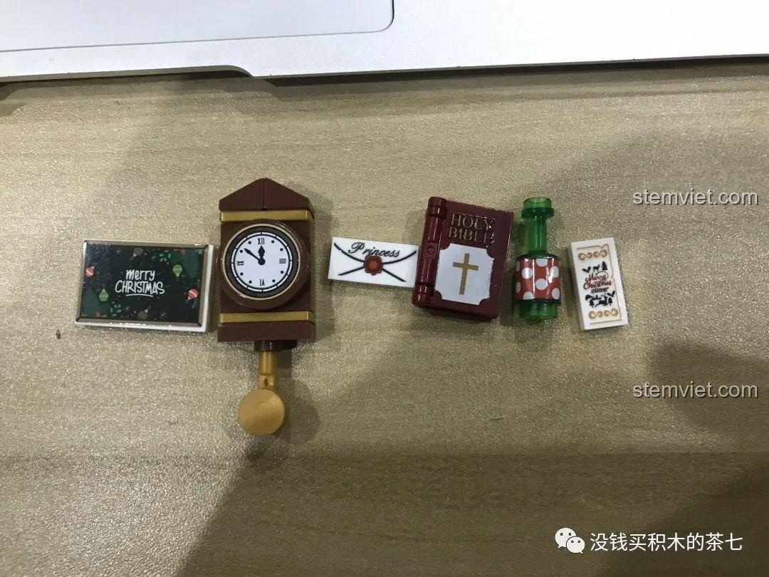 Các phụ kiện nhỏ đi kèm bộ lắp ráp Wekki 506001 Ngôi Nhà Giáng Sinh: đồng hồ, sách, phong bì, pizza.