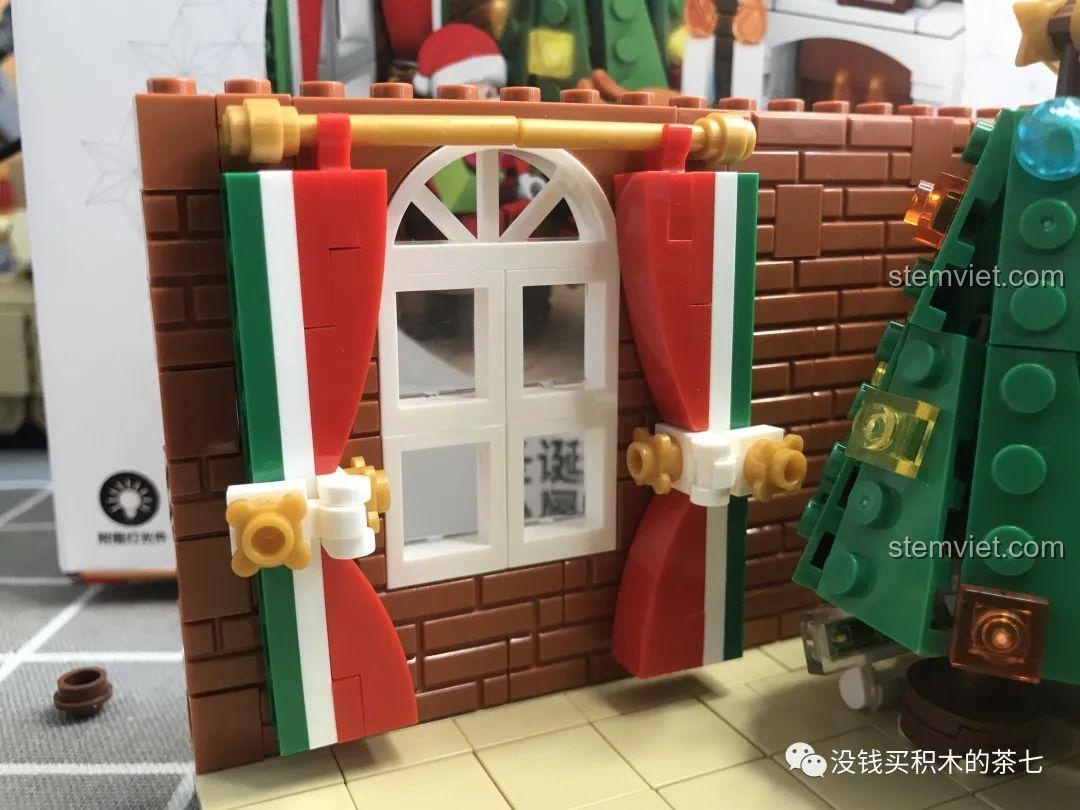 Rèm cửa đã được lắp đặt trên cửa sổ của bộ lắp ráp Wekki 506001 Ngôi Nhà Giáng Sinh.