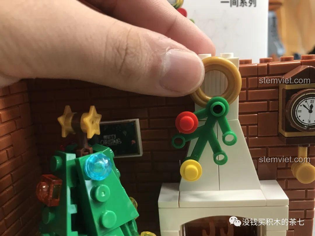 Lắp đặt vòng hoa trang trí trên lò sưởi của bộ lắp ráp Wekki 506001 Ngôi Nhà Giáng Sinh.