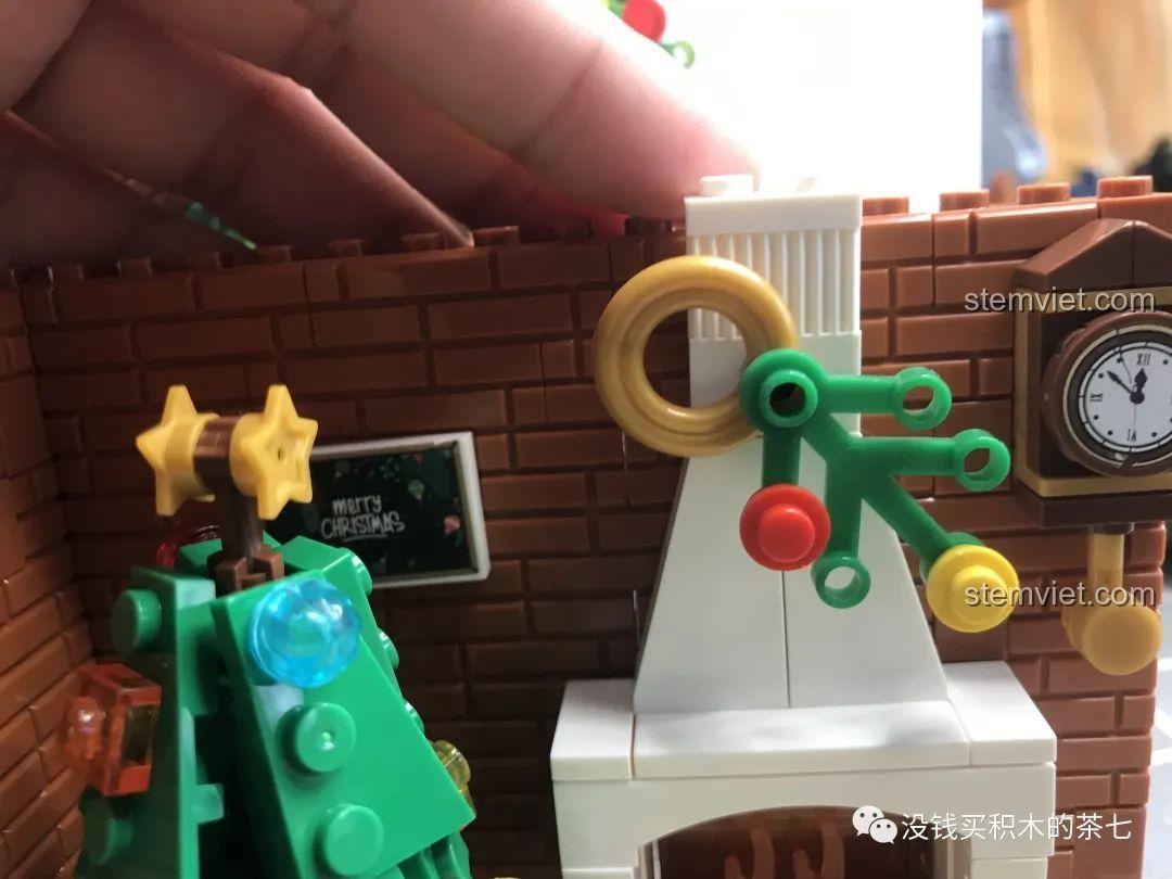 Vòng hoa trang trí đã được cố định trên lò sưởi của bộ lắp ráp Wekki 506001 Ngôi Nhà Giáng Sinh.