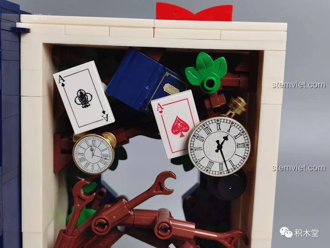 Chi tiết bên trong mô hình sách Wekki 506172 Sách truyện Alice ở xứ sở thần tiên, bao gồm đồng hồ, quân bài và các mảnh ghép cây.