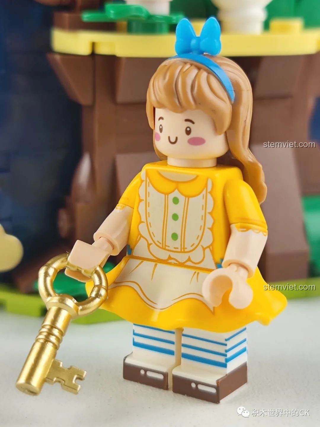 Minifigure cô bé Alice trong bộ đồ chơi lắp ráp Wekki 506172 Sách Truyện Alice ở Xứ Sở Thần Tiên, cầm chiếc chìa khóa vàng.