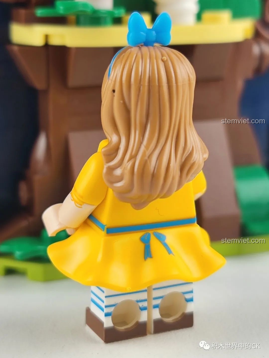 Mặt sau của minifigure cô bé Alice trong bộ lắp ráp Wekki 506172 Sách Truyện Alice ở Xứ Sở Thần Tiên, thể hiện chi tiết tóc và váy.