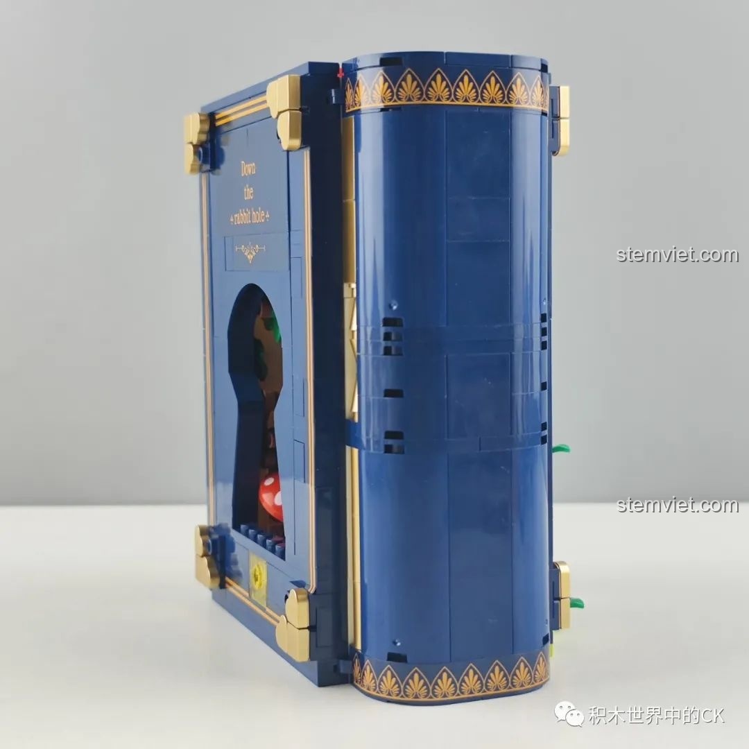 Cạnh bên của mô hình sách đồ chơi lắp ráp Wekki 506172 Sách Truyện Alice ở Xứ Sở Thần Tiên, với chi tiết lỗ khóa và dòng chữ 'Down the rabbit hole'.