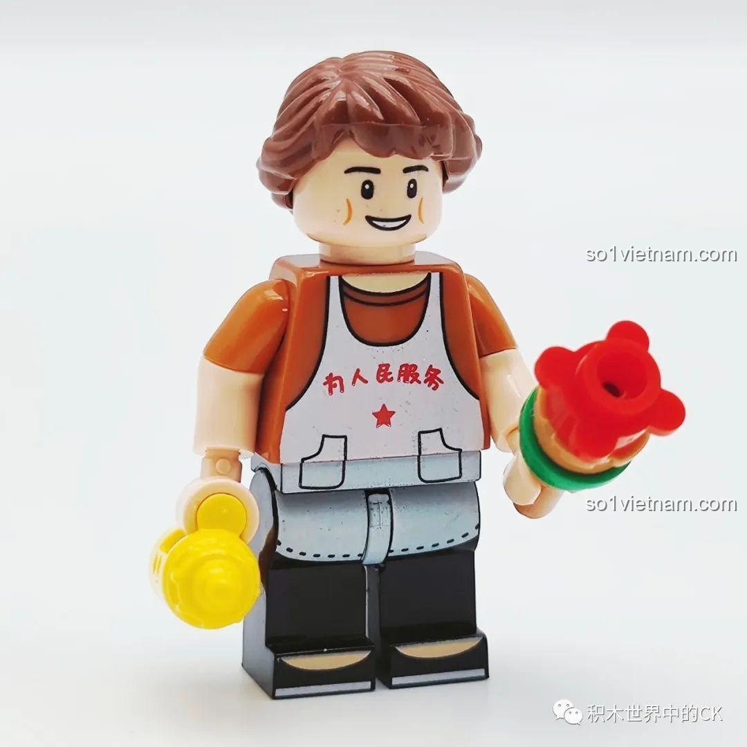 Cảm nhận Wekki 516952D Quầy Xiên Que Chiên: Cận cảnh minifigure người bán xiên que với mái tóc tết bím và tạp dề trắng.