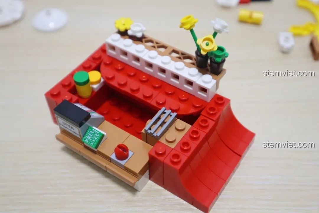 Mô hình cửa hàng gà rán Wekki So Good Little Shop Series 2 đã hoàn thiện, với bàn ghế ngoài trời và xe máy giao hàng.