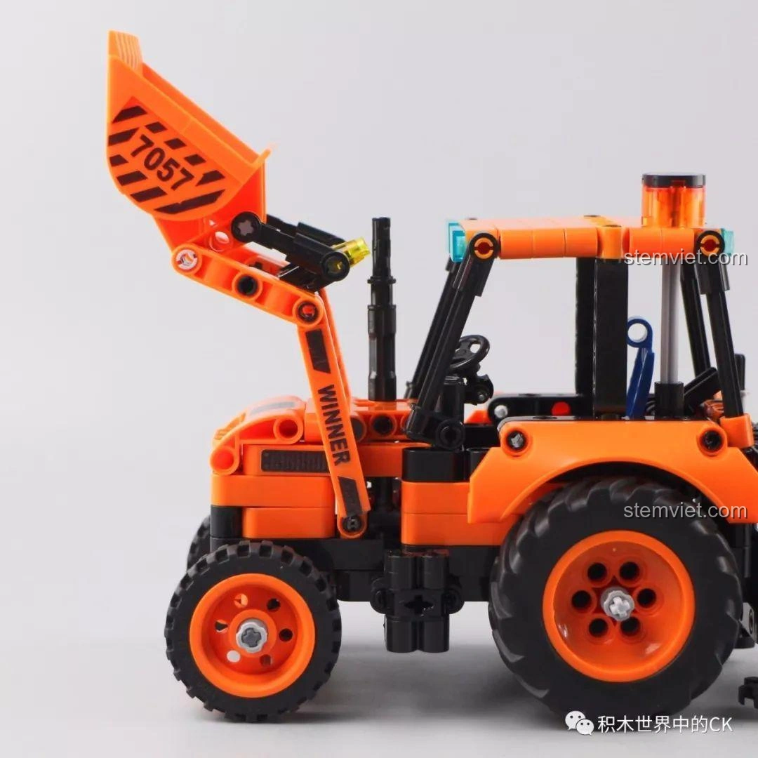 Gầu xúc của mô hình Xe Xúc Đào Đa Năng Winner 7057 được hạ thấp, sẵn sàng xúc vật liệu.