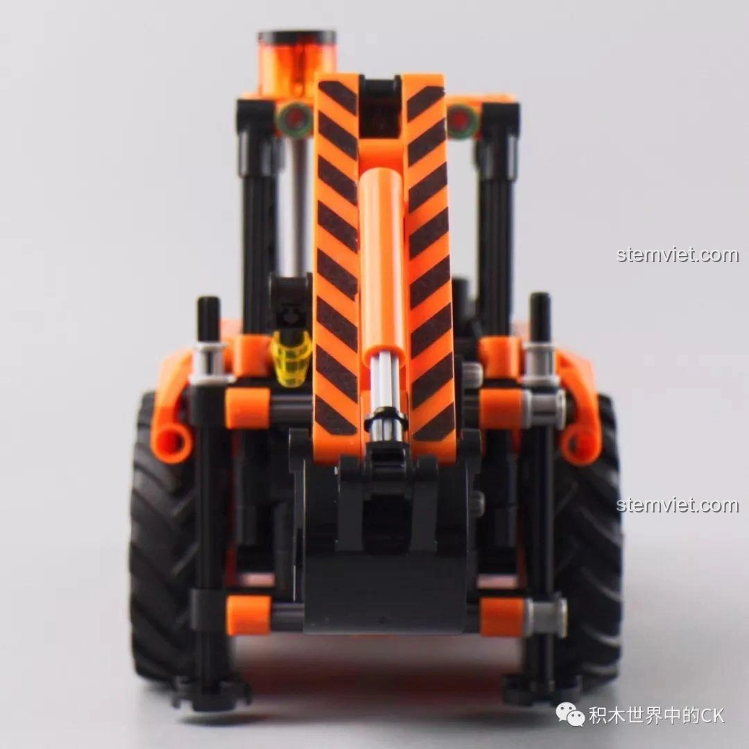 Góc nhìn từ phía sau của mô hình Xe Xúc Đào Đa Năng Winner 7057, nổi bật các chi tiết kỹ thuật và bánh xe.