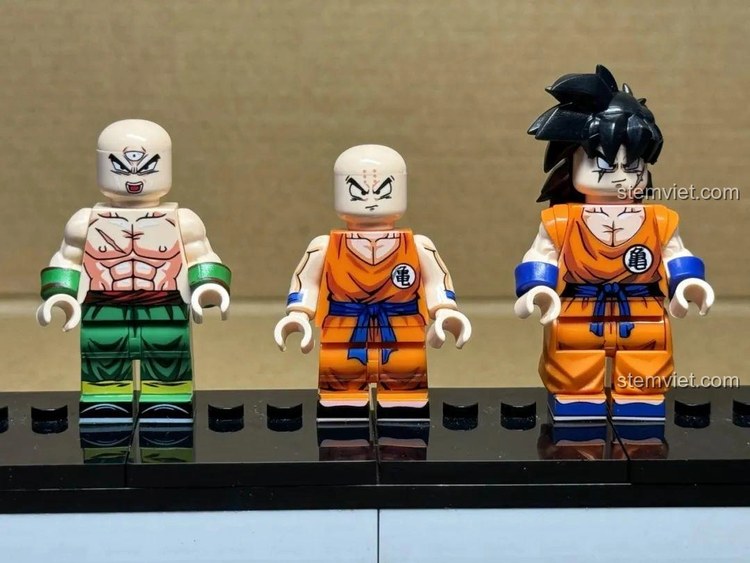 Hình ảnh nhóm ba minifigure Krillin, Thiên Tân Phạn và Yamcha từ bộ WM6180 Dragon Ball Z, đứng cạnh nhau trên đế trưng bày.