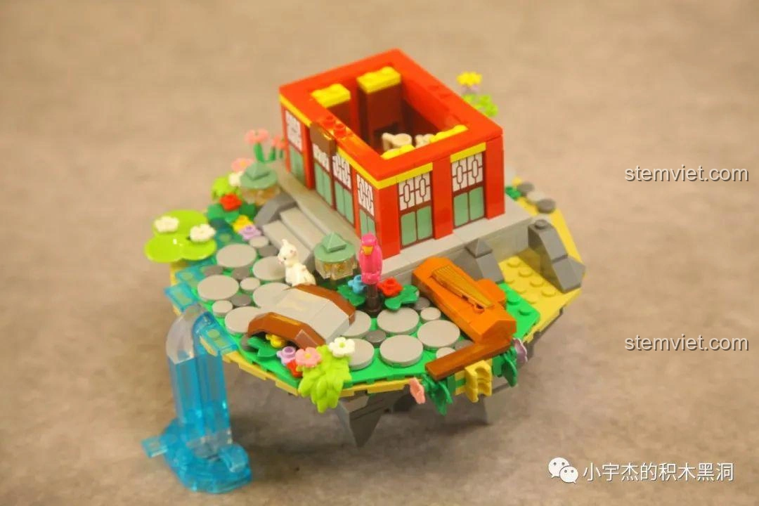 Góc nhìn tổng thể tòa lầu và cảnh quan xung quanh trong quá trình lắp ráp bộ WOMA C0349 Túy Hoa Các, với thác nước và cây cầu.