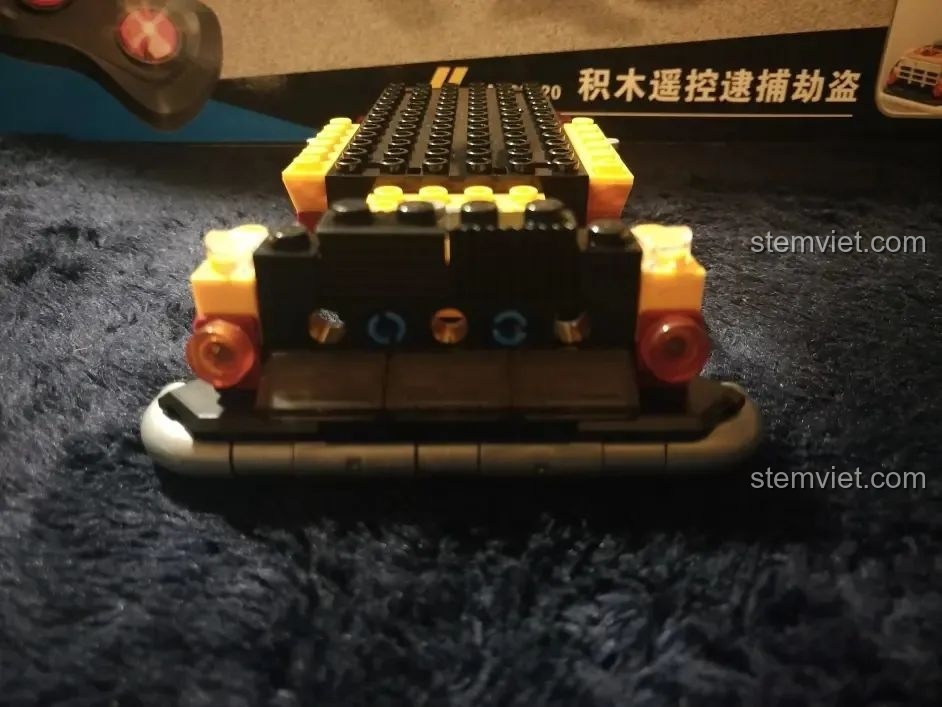 Cận cảnh phần đầu xe từ phía sau của bộ lắp ghép Xe Cảnh Sát Cứu Hộ Điều Khiển Từ Xa HA389120, hiển thị chi tiết đèn và ống xả.