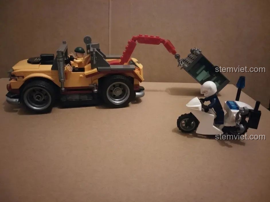 Chiếc xe cảnh sát cứu hộ điều khiển từ xa HA389120 đang kéo két sắt, thể hiện chức năng cứu hộ và khả năng chơi đa dạng.