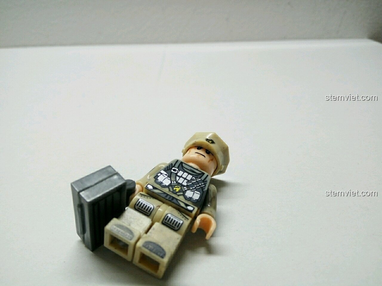 Minifigure lính với mũ lưỡi trai và vali, chụp từ góc nghiêng, làm nổi bật phụ kiện.