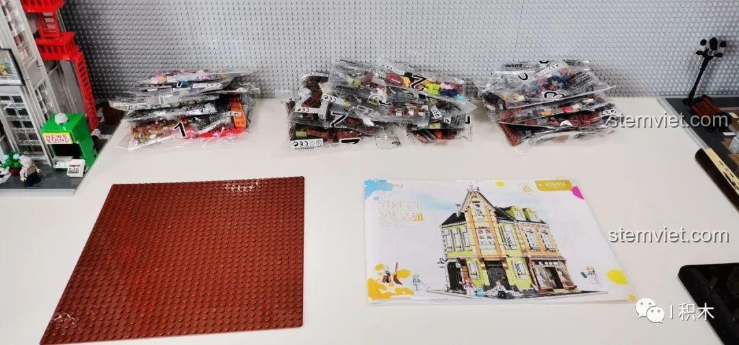 Các túi chi tiết được phân loại cùng sách hướng dẫn và đế lắp ráp của bộ Tòa Nhà Góc Phố Đa Năng Zhe Gao QL0919.