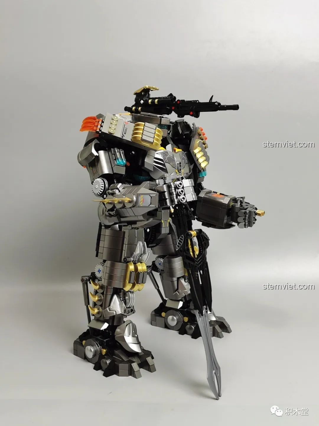 Góc nhìn bên cạnh của Robot Batmech Hạng Nặng khi được trang bị đầy đủ vũ khí, bao gồm súng và đao.