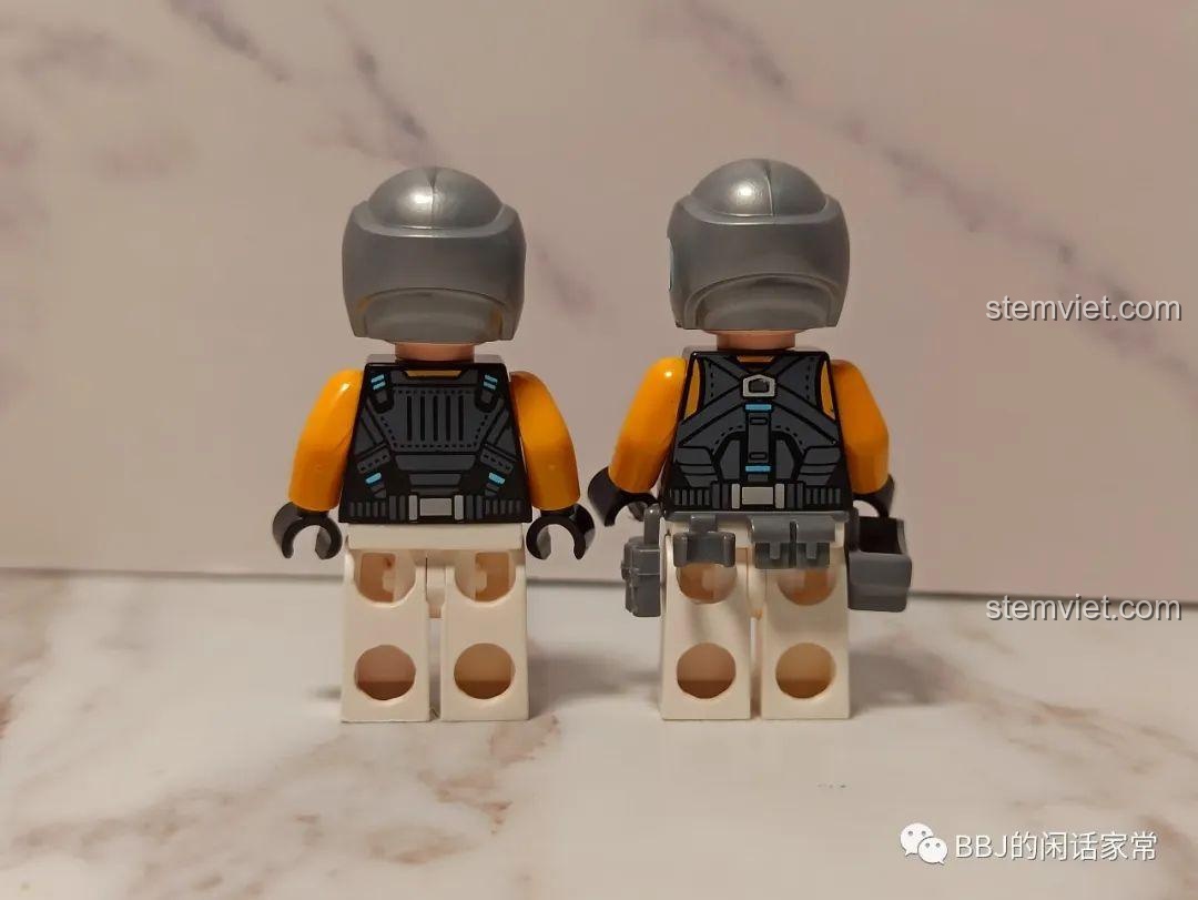 Mặt sau của hai minifigure nam chiến binh, George và George, với trang phục phi hành gia và các chi tiết in ấn.