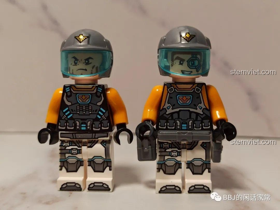 Hai minifigure nam chiến binh, George và George, với mũ bảo hiểm xám, kính chắn gió xanh và trang phục phi hành gia.