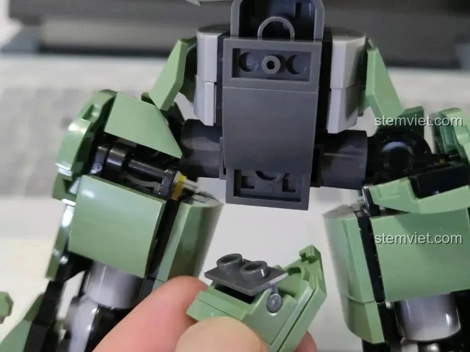 Robot Diệt Tận Thế Sluban M38-B1153 giơ tay lên cao, thể hiện biên độ cử động ấn tượng.