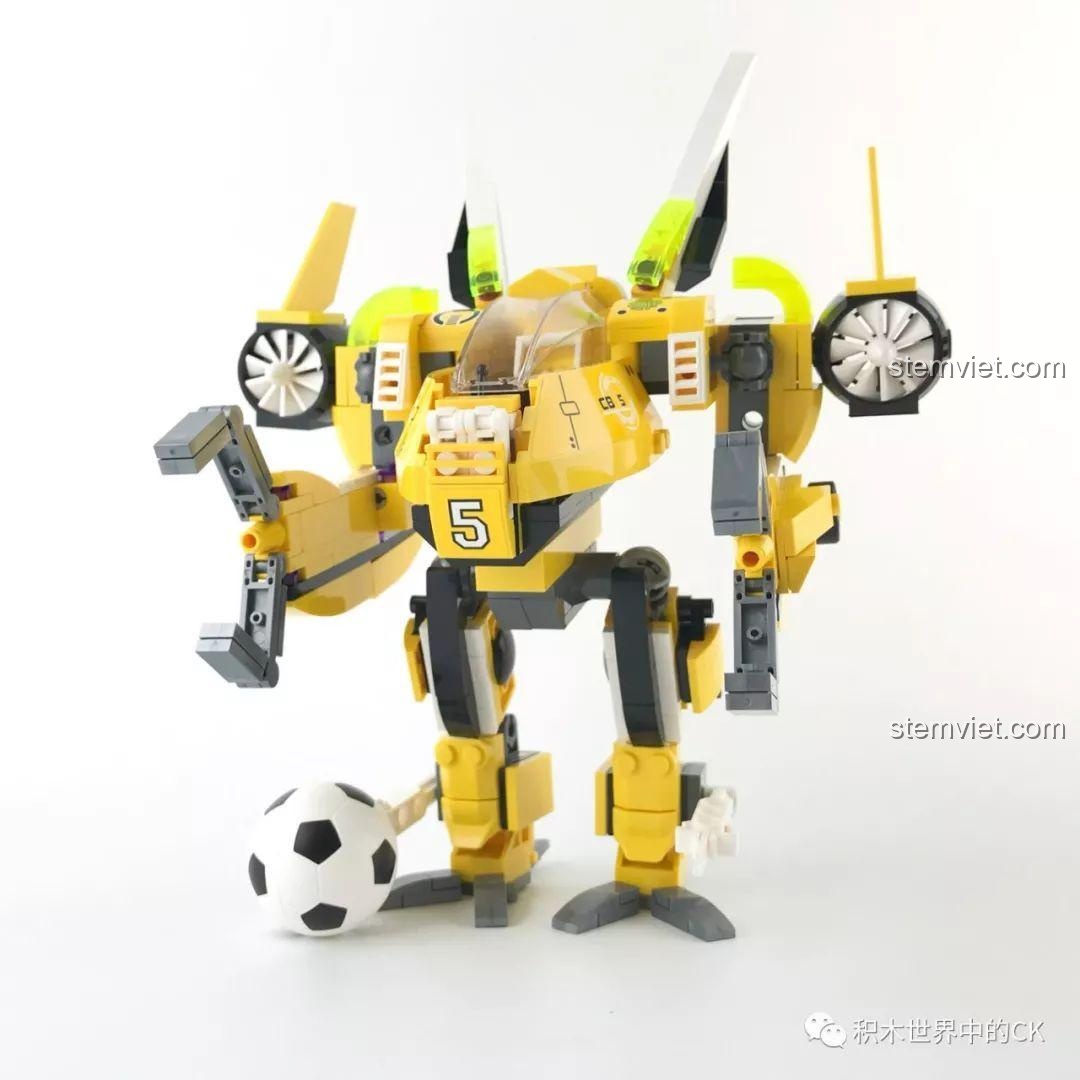 Mô hình Robot bóng đá QMAN 3004 nhìn từ phía trước với trái bóng, thiết kế màu vàng nổi bật.