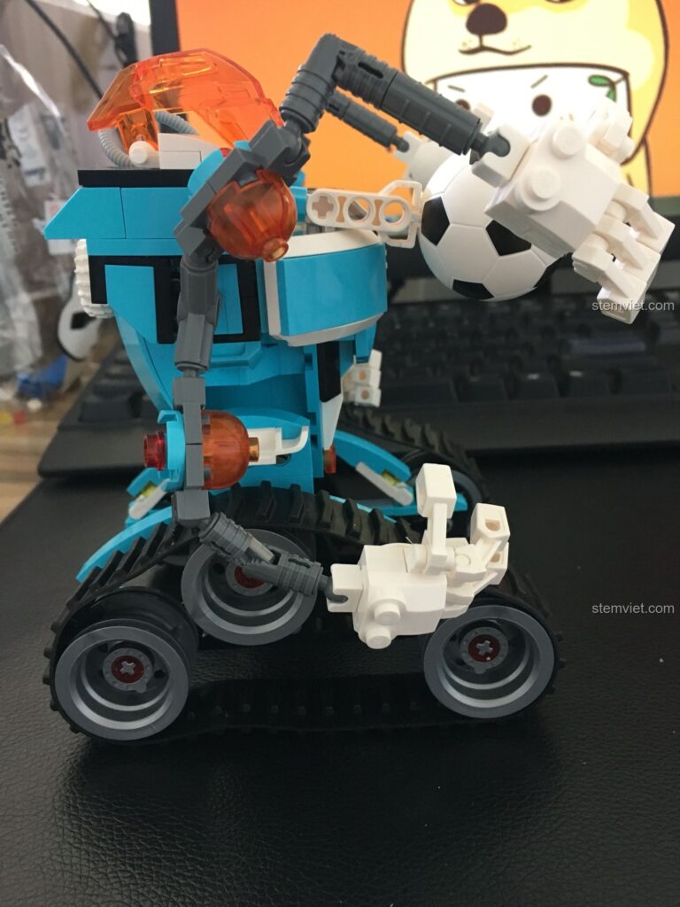 Robot Thủ Môn Tay Sắt QMAN 3003 với cánh tay robot chi tiết và bóng đá.