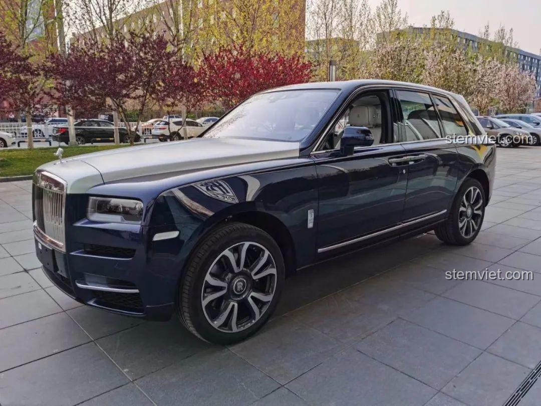 Rolls-Royce Cullinan đời thực màu xanh đen, nắp capo bạc, chụp cận cảnh bên hông xe, bánh xe lớn.