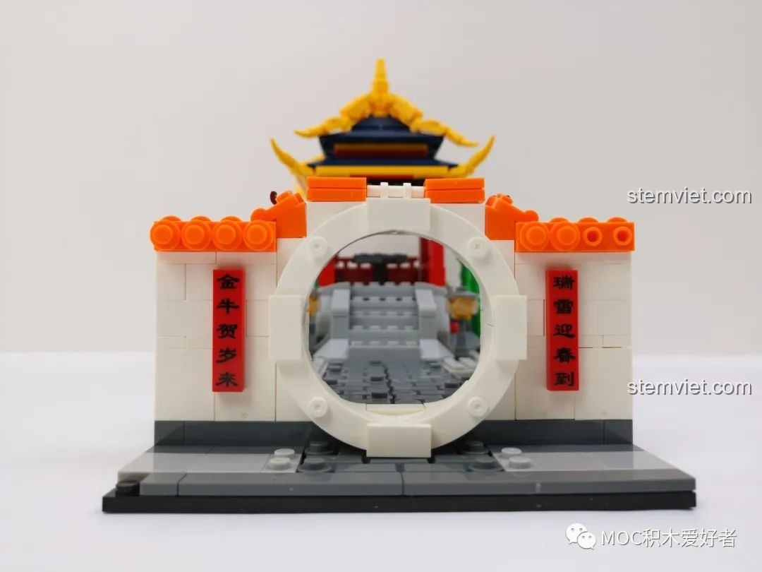 Cổng vào khu vực đình nghỉ của sa bàn Lễ hội Đèn lồng trong Vườn cho bé 6+, với câu đối hai bên.