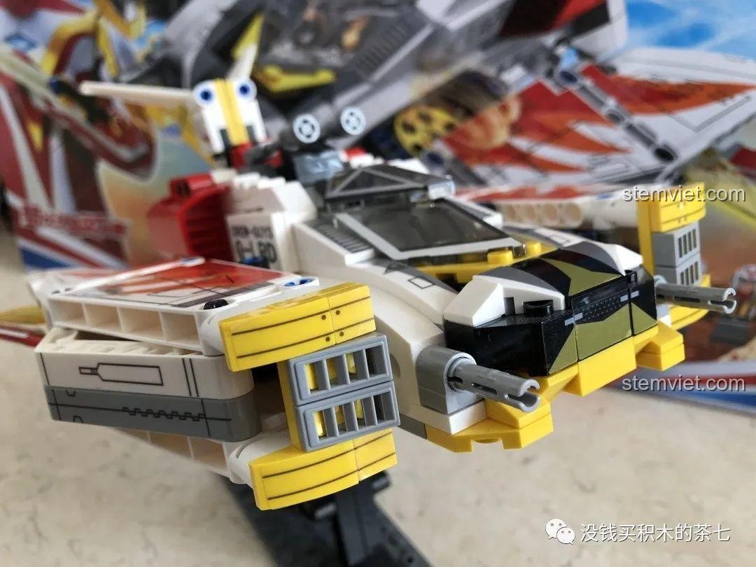 Cận cảnh minifigure phi công GUYS với mũ bảo hiểm trắng đỏ, chi tiết trang phục màu vàng và xám.