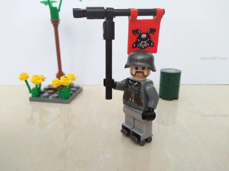 Minifigure lính Đức cầm cờ để so sánh kích thước với các mô hình máy bay mini SEMBO 11519.