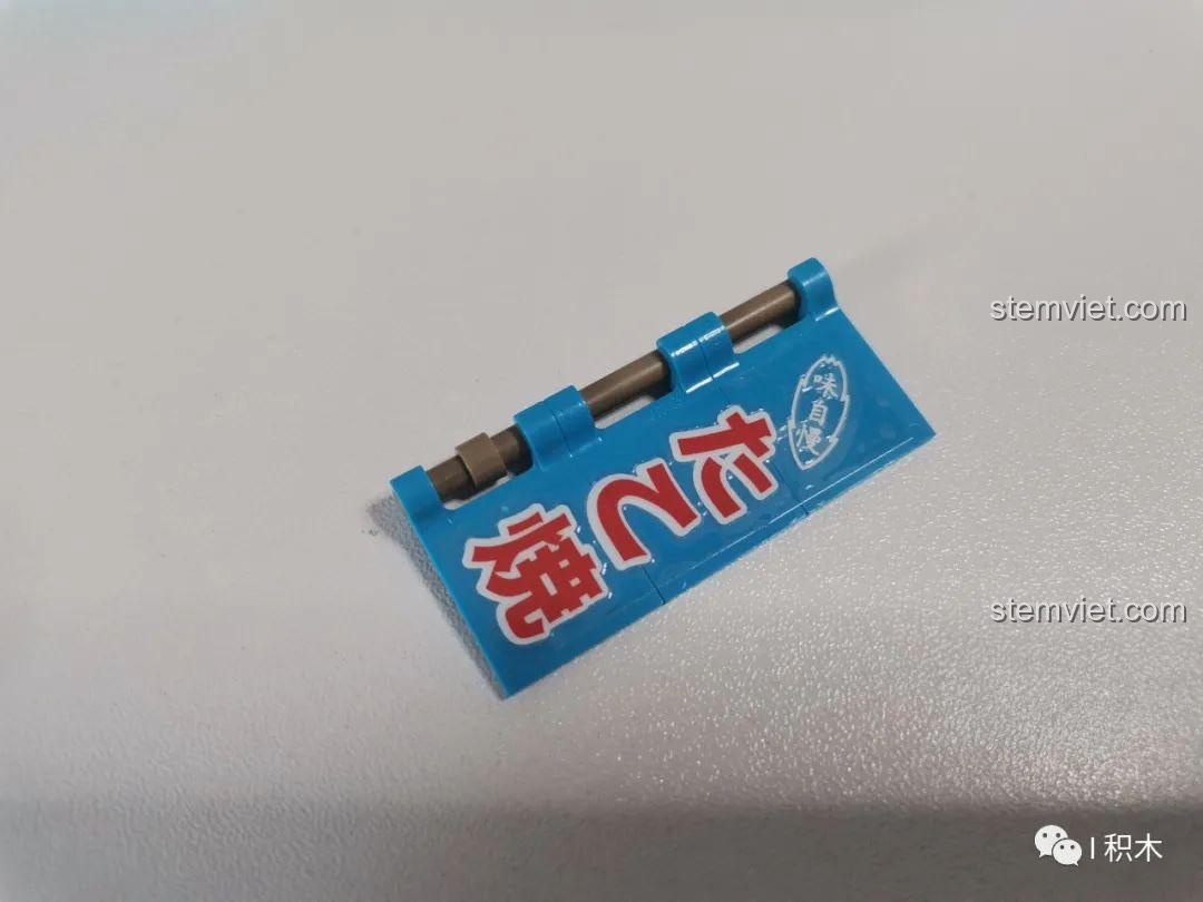 Biển hiệu màu xanh nổi bật với chữ tiếng Nhật, một chi tiết của bộ lắp ráp Cửa hàng Takoyaki Osaka SEMBO 601072.