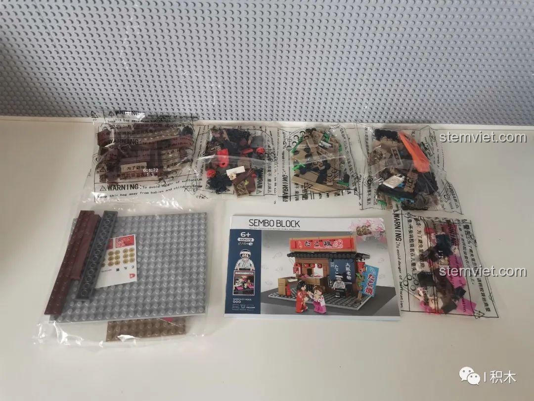 Các túi mảnh ghép và sách hướng dẫn của bộ xếp hình Cửa hàng Takoyaki Osaka SEMBO 601072 sau khi đập hộp.