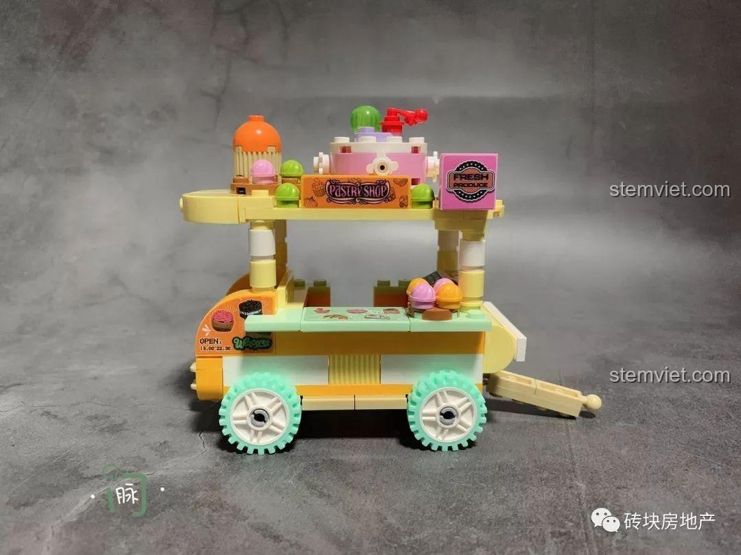 Chi tiết xe bán bánh ngọt Sembo 601109, một phần của bộ 4 Xe Đẩy Bán Hàng Rong Mini, với bánh xe xanh mint và các loại bánh.