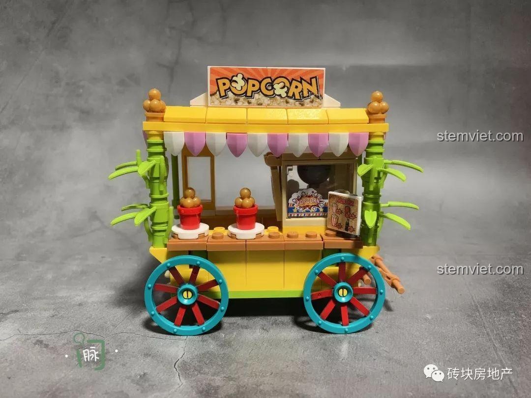 Chi tiết xe bán bắp rang bơ Sembo 601110, một phần của bộ 4 Xe Đẩy Bán Hàng Rong Mini, với biển hiệu POPCORN và trang trí cây xanh.