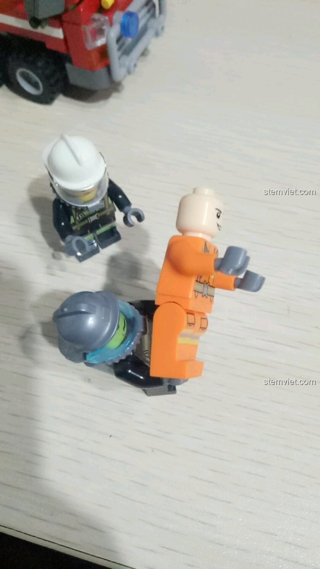 Minifigure lính cứu hỏa bị đồng đội đá vào đám cháy trong kịch bản cứu hỏa của bộ SEMBO 603034.