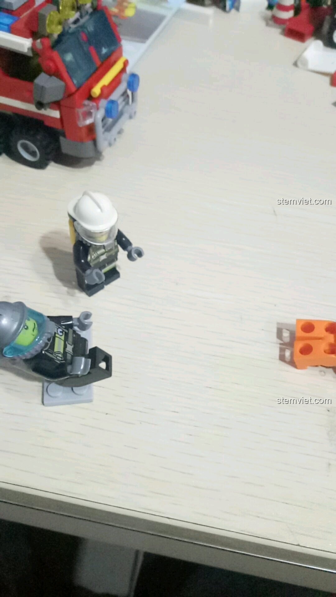 Minifigure lính cứu hỏa nằm bất động sau khi bị đá vào đám cháy trong kịch bản cứu hỏa của bộ SEMBO 603034.