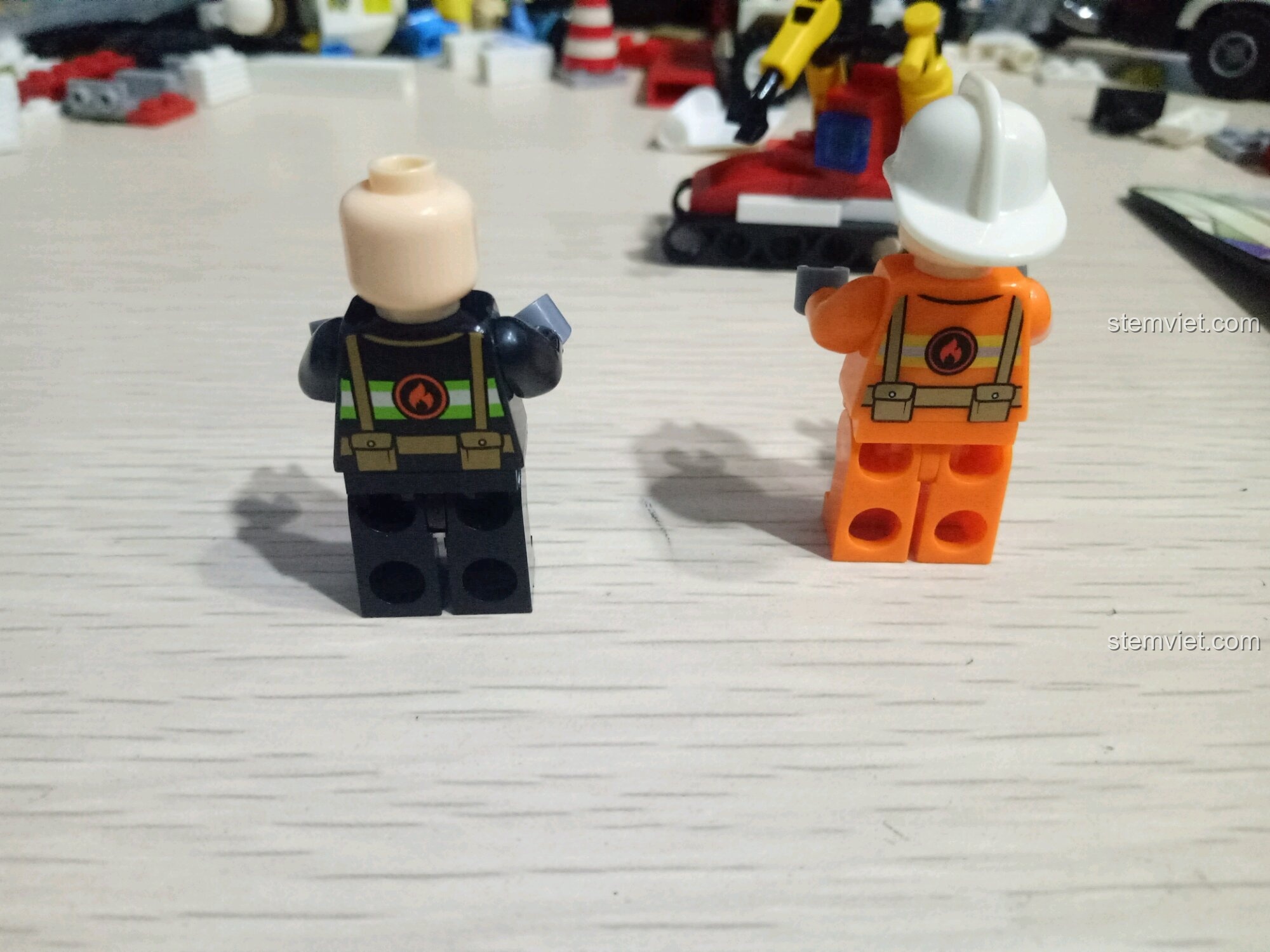 Hai minifigures lính cứu hỏa nhìn từ phía sau, thể hiện chi tiết in ấn trên bộ đồ của bộ SEMBO 603034.